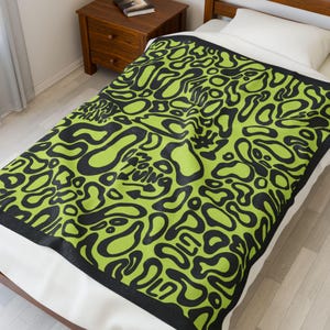 Pode incluir: Uma caneca de cerâmica branca com uma alça preta e o texto "But First, Coffee" em negrito preto. A caneca está sobre um fundo neutro, destacando seu design simples.