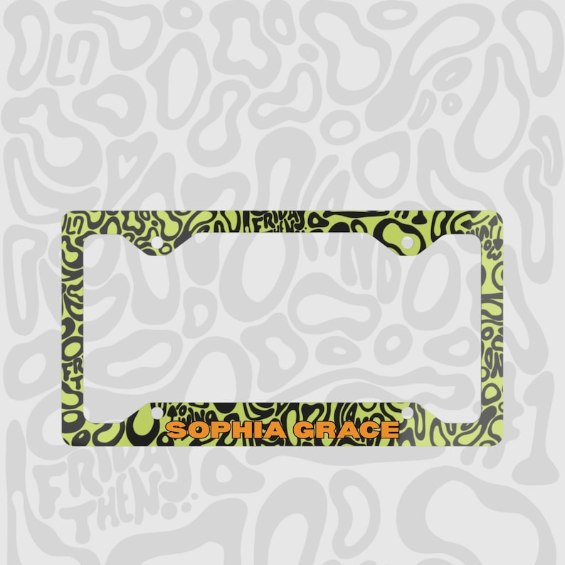 Green and black f1 themed lando norris car license plate frame is shown against a black and white lando norris pattern. Personalised name in orange is on the bottom edge of the frame. 

Lando Norris F1 License Plate Frame: Green and black pattern, Aluminum