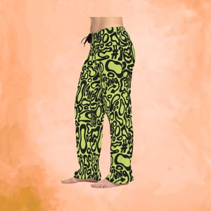 May include: Lime green pajama pants with a black abstract pattern and drawstring waist. The pants feature a repeating design of organic shapes and the text "#WING FRIDAY". The pajama pants are made of a soft material.