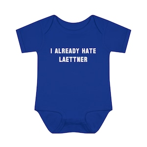 Peut inclure: Un body bébé bleu royal avec un texte blanc qui dit "I ALREADY HATE LAETTNER".