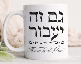 May include: White ceramic mug with black Hebrew text that reads "Gam Zeh Ya'avor" and the English translation "This Too Shall Pass".