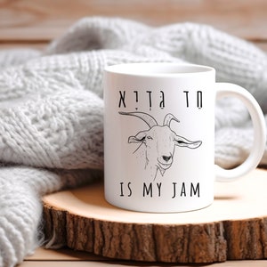 May include: White ceramic mug with a black and white illustration of a goat and the text "Goats are my jam".