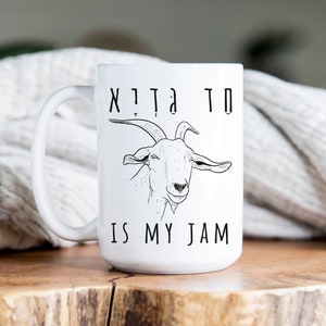 May include: White ceramic mug with a black and white illustration of a goat and the text "Goat is my jam".