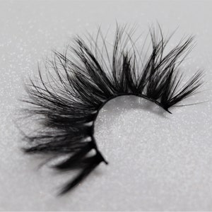 May include: A pair of black false eyelashes with a dramatic, wispy, and flared design. The lashes are designed to add volume and length to the natural lashes.
