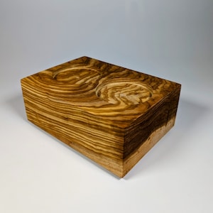 Könnte beinhalten: Ein Holzhalter mit zwei runden Aussparungen, perfekt für kleine Gegenstände wie Kerzen oder Seife. Der Halter ist aus hellbraunem Holz mit dunkelbraunen Streifen.