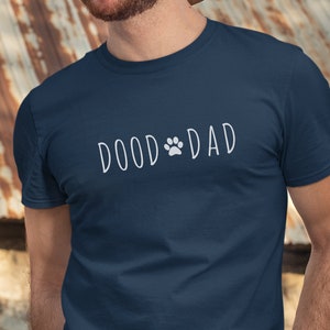 May include: A navy blue t-shirt with the text 'DOOD DAD' in white with a paw print between the words.