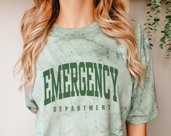 May include: A light green t-shirt with a distressed look. The shirt has the text "EMERGENCY DEPARTMENT" printed in dark green.