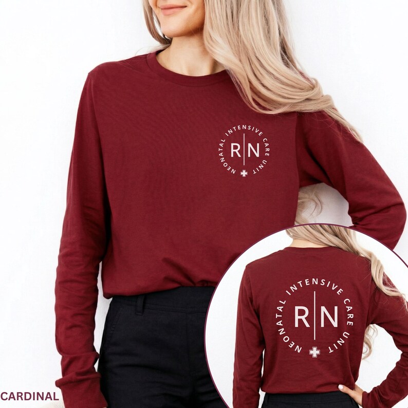May include: A cardinal red long-sleeve shirt featuring a white circular graphic on the left chest and a larger version on the back. The graphic contains the text RN, Neonatal Intensive Care Unit, and a small cross symbol in a circular layout.