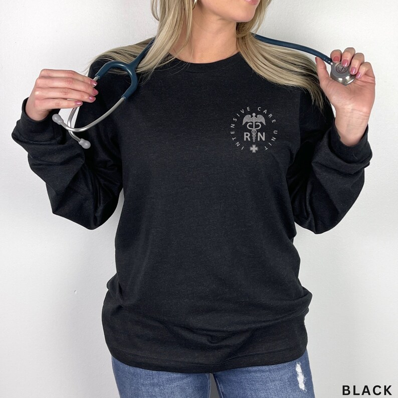 May include: Black long-sleeve shirt with a silver graphic of a medical symbol and the text "INTENSIVE CARE UNIT RN".