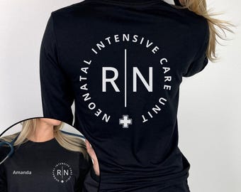 May include: A black long-sleeve shirt featuring a white graphic on the back with the text Neonatal Intensive Care Unit surrounding the letters RN and a small cross symbol. The front includes the name Amanda and a smaller version of the graphic.