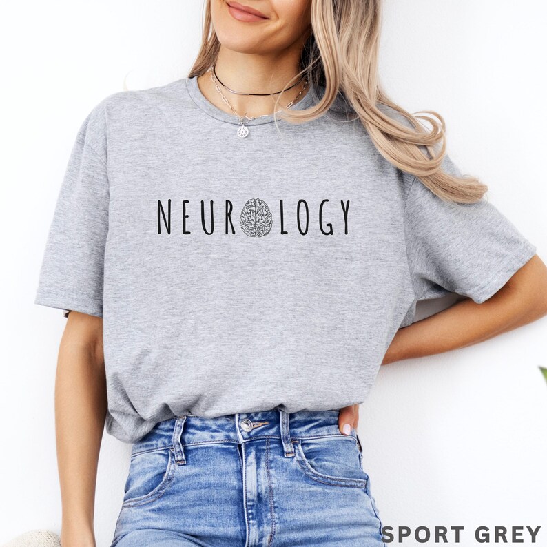 K&ouml;nnte beinhalten: Ein hellgraues T-Shirt mit dem Wort "NEUROLOGIE" in Schwarz aufgedruckt, mit einer Gehirngrafik. Das Shirt besteht aus einem weichen Material und eignet sich f&uuml;r Freizeitkleidung. Der Text "SPORT GREY" ist unten aufgedruckt.