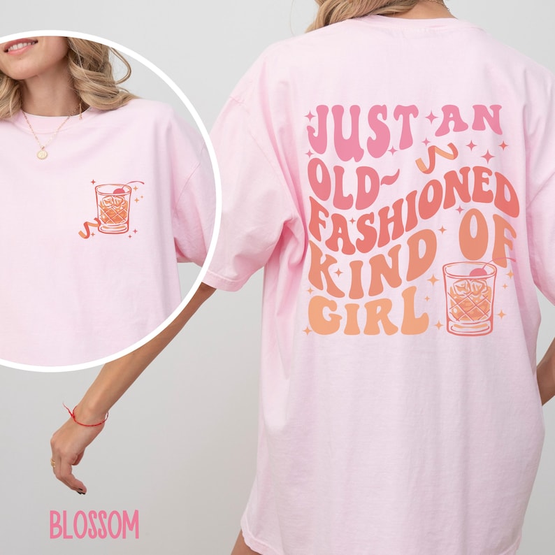 Peut inclure: T-shirt rose surdimensionn&eacute;e avec le texte "Just an old-fashioned kind of girl" dans une police r&eacute;tro avec un graphique de verre &agrave; cocktail. Le t-shirt a un petit graphique de verre &agrave; cocktail sur le devant.
