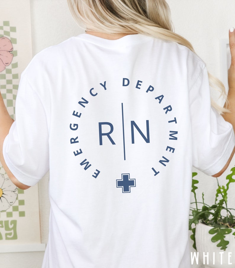 May include: White t-shirt with a navy blue design on the back. The design includes the words "EMERGENCY DEPARTMENT" in a circle around the letters "RN" and a cross symbol. The word "WHITE" is visible at the bottom right.