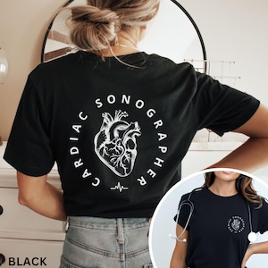 May include: Black t-shirt with a white graphic of a heart and the words "CARDIAC SONOGRAPHER" in a circular design. A small EKG line is below the heart graphic. The shirt is visible from the back.