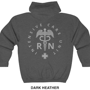 Peut inclure: Sweat-shirt &agrave; capuche gris chin&eacute; fonc&eacute; avec un motif blanc repr&eacute;sentant un symbole m&eacute;dical, un serpent enroul&eacute; autour d'un b&acirc;ton, avec les lettres "RN" et une croix. Le texte autour du symbole est "Intensive Care Unit".