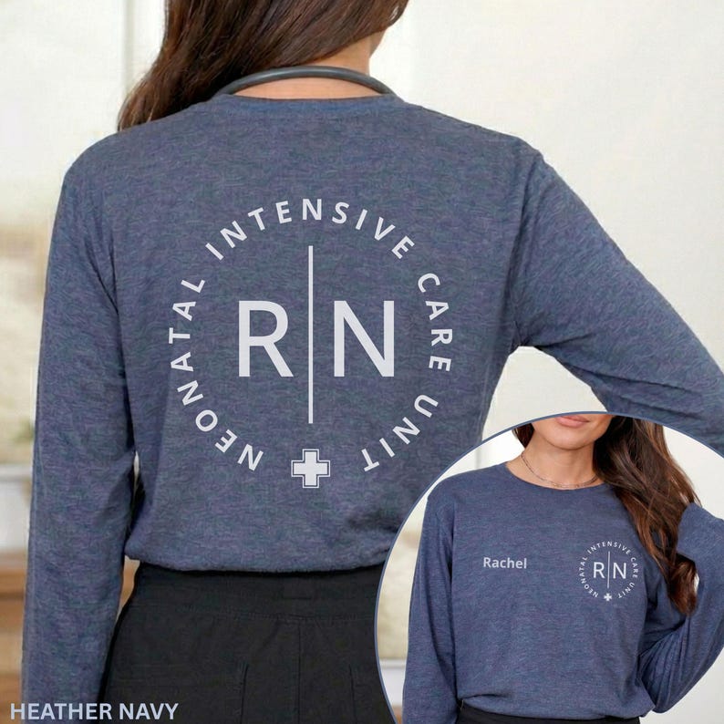 May include: A heather navy long-sleeve shirt featuring a white circular graphic on the back with the text Neonatal Intensive Care Unit and RN. The front includes the name Rachel and a smaller version of the same circular RN graphic.