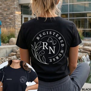 Puede incluir: Camiseta negra con un dise&ntilde;o circular blanco en la espalda. El dise&ntilde;o incluye las palabras "REGISTERED NURSE", las letras "RN", un estetoscopio y elementos florales. La camiseta la lleva una persona.