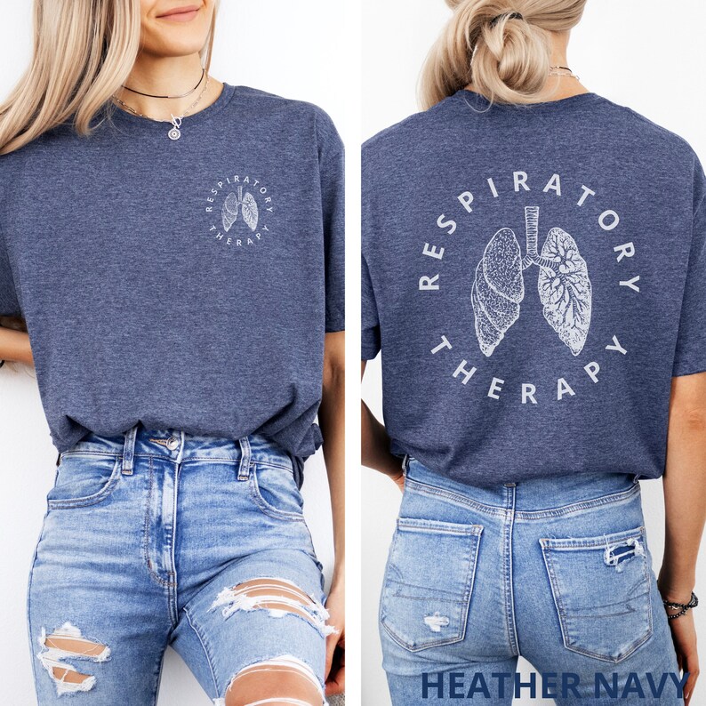 Pode incluir: T-shirt azul marinho mesclado com um gr&aacute;fico branco de pulm&otilde;es e as palavras "RESPIRATORY THERAPY" em um design circular. O mesmo design est&aacute; na frente e nas costas da camiseta. A camiseta &eacute; combinada com jeans azuis.