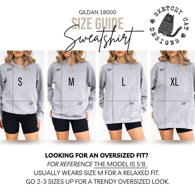 Op de afbeelding: Een Gildan 18000 sweatshirt maattabel met vier grijze sweatshirts in de maten S, M, L en XL. Elke afbeelding toont lengte- en breedtematen in inches. De tekst bevat 'Sketchy Cat Designs', 'Looking for an oversized fit?' en modelinformatie.