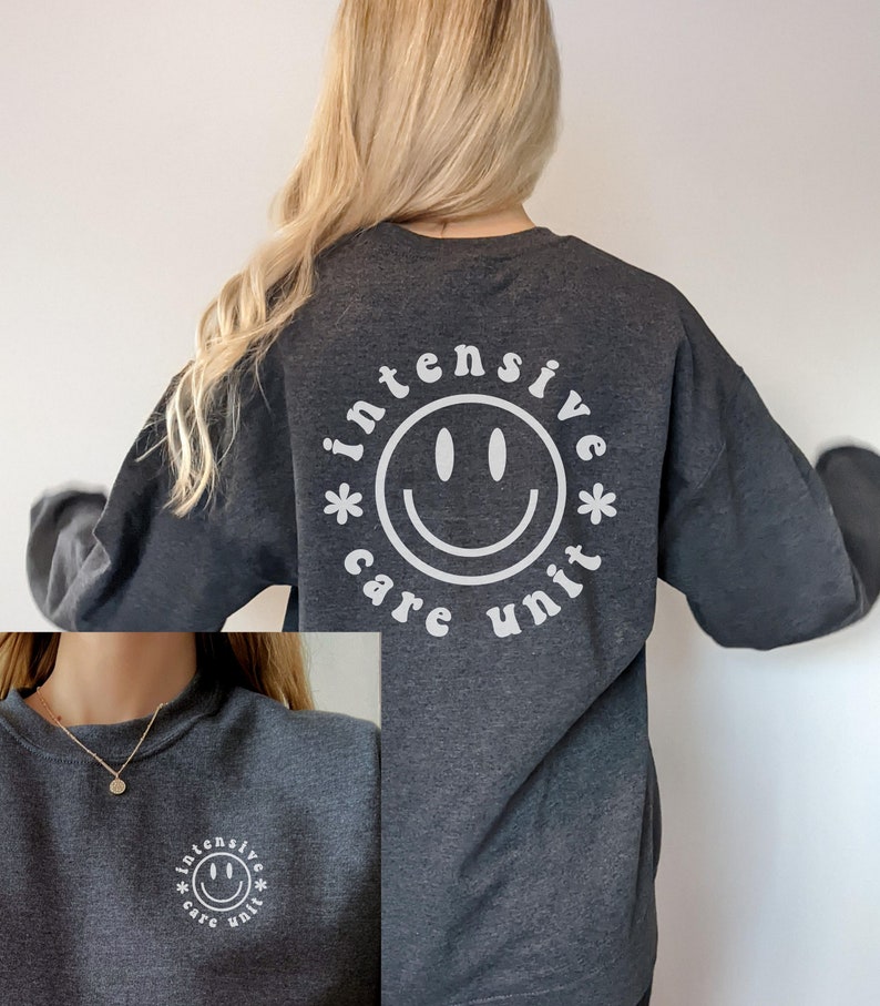 May include: A dark gray sweatshirt with a white smiley face graphic and the text "*intensive care unit*" around the smiley face.