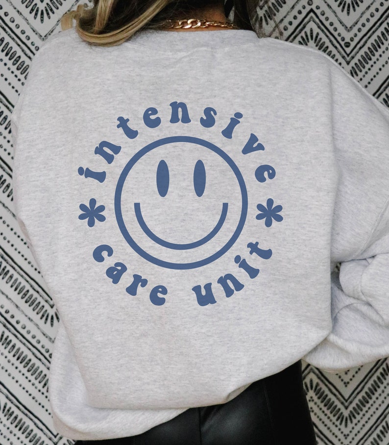 May include: Gray sweatshirt with a blue graphic of a smiley face and the text "*intensive care unit*"