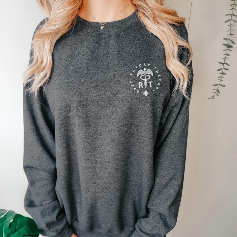 May include: A dark gray sweatshirt with a white graphic of a respiratory therapist symbol and the text "Respiratory Therapy" around it.