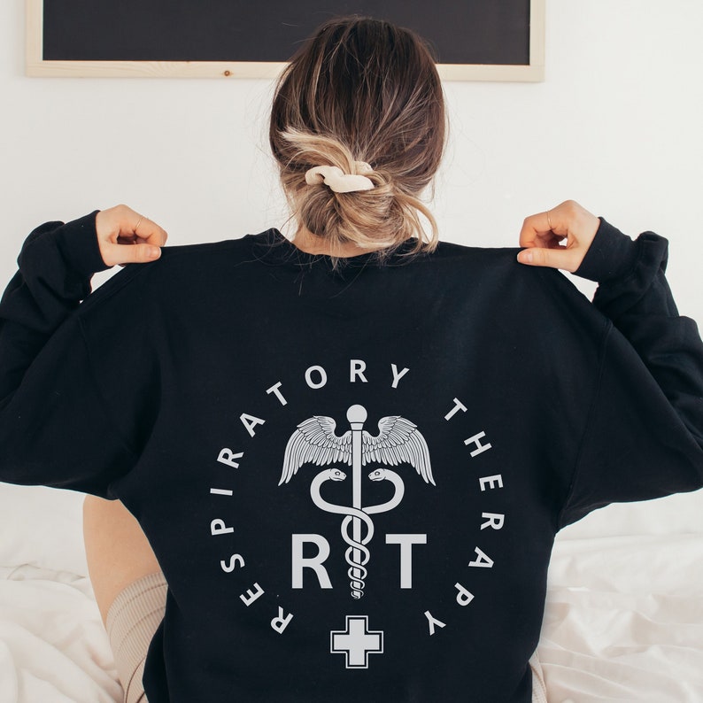 May include: Black sweatshirt with a white graphic of a medical symbol, a snake wrapped around a staff with wings, and the text "Respiratory Therapy RT".