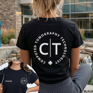 May include: A black t-shirt featuring a white circular graphic on the back with the text Computed Tomography Technologist and the letters CT separated by a vertical line. The front includes the name Amanda and a smaller matching circular logo.