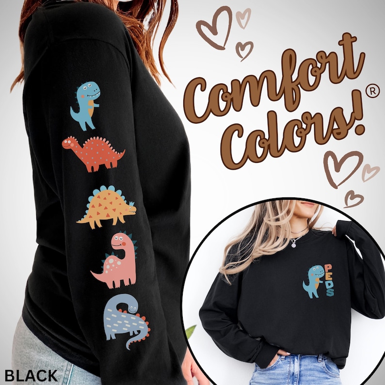 May include: Black long-sleeve shirt with colorful dinosaur graphics on the left sleeve. The shirt features the text "Comfort Colors!" and a small dinosaur graphic with the word "PEDS" on the chest. The shirt is a comfortable, casual style.