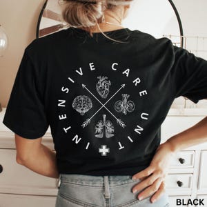 May include: Black t-shirt with a white circular design featuring the words "Intensive Care Unit" and anatomical illustrations of the brain, heart, lungs, and kidneys. The shirt also has a cross symbol at the bottom.