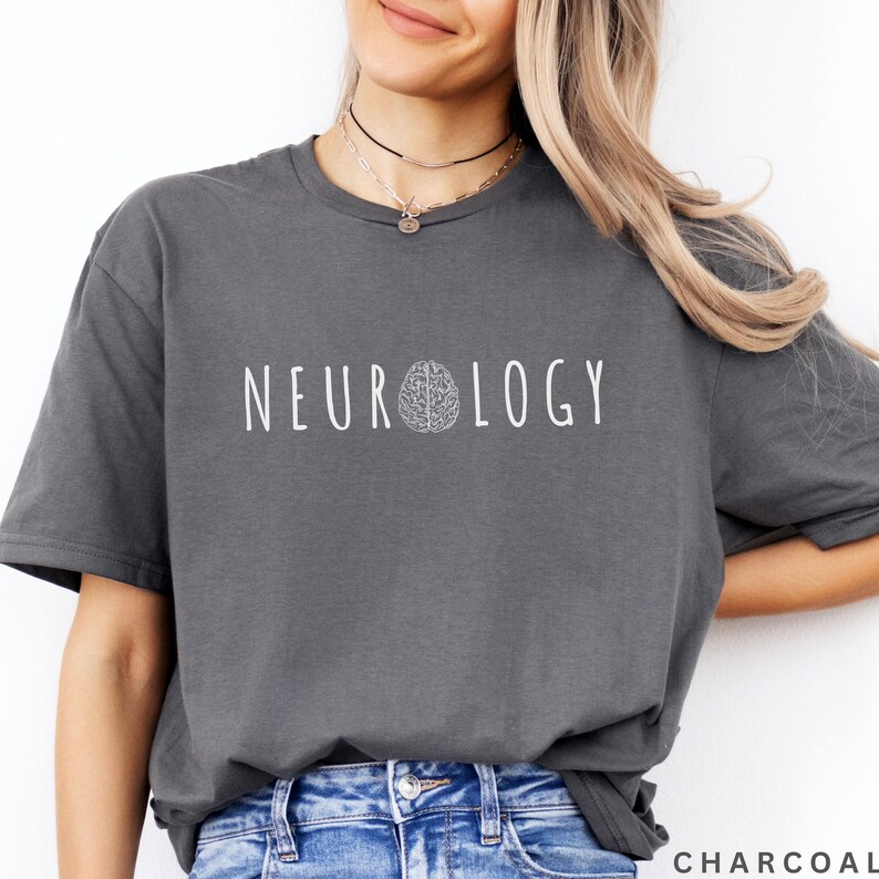 K&ouml;nnte beinhalten: Anthrazitfarbenes T-Shirt mit dem wei&szlig;en Wort "NEUROLOGY" und einer Gehirngrafik. Das Shirt hat eine lockere Passform. Das Wort "CHARCOAL" ist unten rechts aufgedruckt.