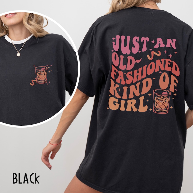 Peut inclure: T-shirt noire surdimensionn&eacute;e avec un imprim&eacute; graphique d'un verre &agrave; cocktail et le texte "Just an old-fashioned kind of girl".
