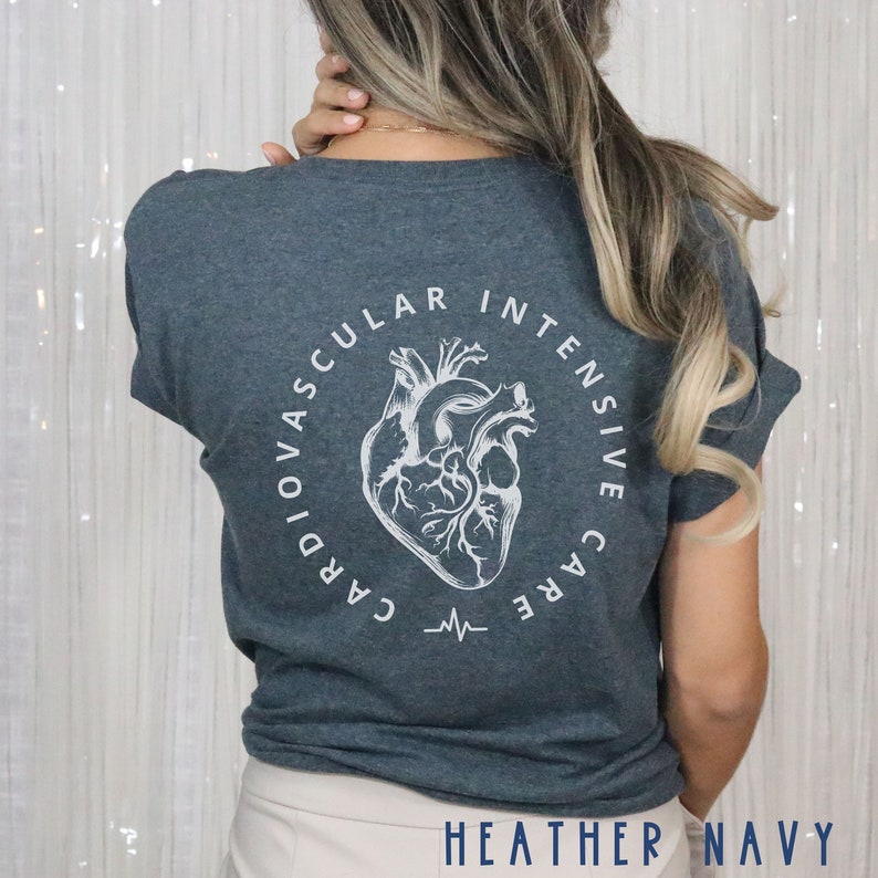 May include: Heather navy t-shirt with a white anatomical heart design encircled by the words "Cardiovascular Intensive Care." A heartbeat line graphic is below the heart. The text "HEATHER NAVY" is at the bottom.