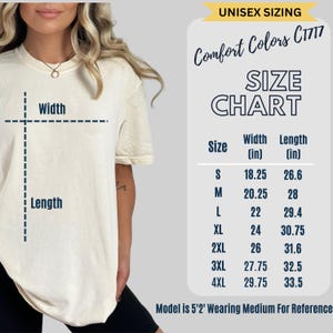 Puede incluir: Camiseta color crema con una tabla de tallas, que incluye medidas de ancho y largo en pulgadas. La tabla enumera las tallas de la S a la 4XL. El texto "UNISEX SIZING" est&aacute; en la parte superior. La modelo lleva una talla M como referencia.
