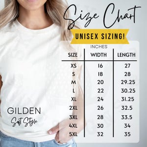 Puede incluir: Una camiseta blanca con una tabla de tallas para tallas unisex. La tabla enumera las tallas XS a 5XL, con las medidas correspondientes en pulgadas para el ancho y el largo. La camiseta es de Gildan Soft Style.