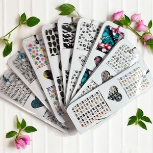 May include: A set of 10 colorful bookmarks with various designs, including musical notes, cats, and abstract patterns. The bookmarks are packaged in clear plastic sleeves.