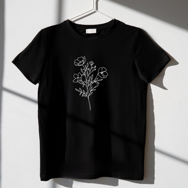 May include: A black t-shirt with a white line drawing of a flower on the front.