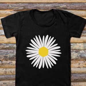 May include: A black t-shirt with a white daisy graphic. The daisy has a yellow center.
