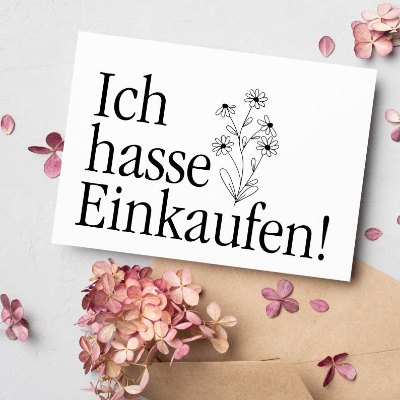 Op de afbeelding: Een witte kaart met zwarte tekst die "Ich hasse Einkaufen!" zegt met een eenvoudige zwarte lijntekening van een boeket bloemen.