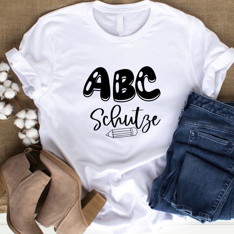Pode incluir: Camiseta branca com texto preto que diz "ABC Schutze" com um l&aacute;pis abaixo do texto.