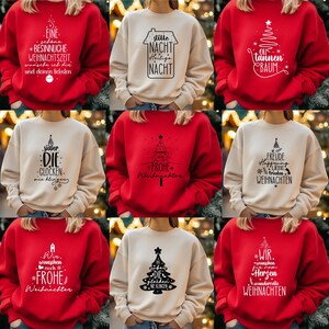 Könnte beinhalten: Eine Auswahl an Weihnachtspullovern in Rot und Creme. Jeder Pullover hat ein schwarzes Grafik- und Textdesign, darunter Weihnachtsbäume und festliche Phrasen. Die Pullover sind aus einem weichen Material.