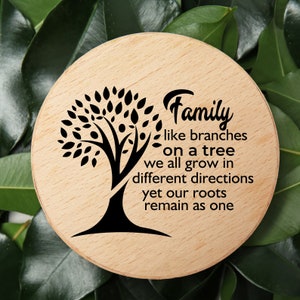 May include: A round wooden sign with a black silhouette of a tree and the text "Family like branches on a tree we all grow in different directions yet our roots remain as one".