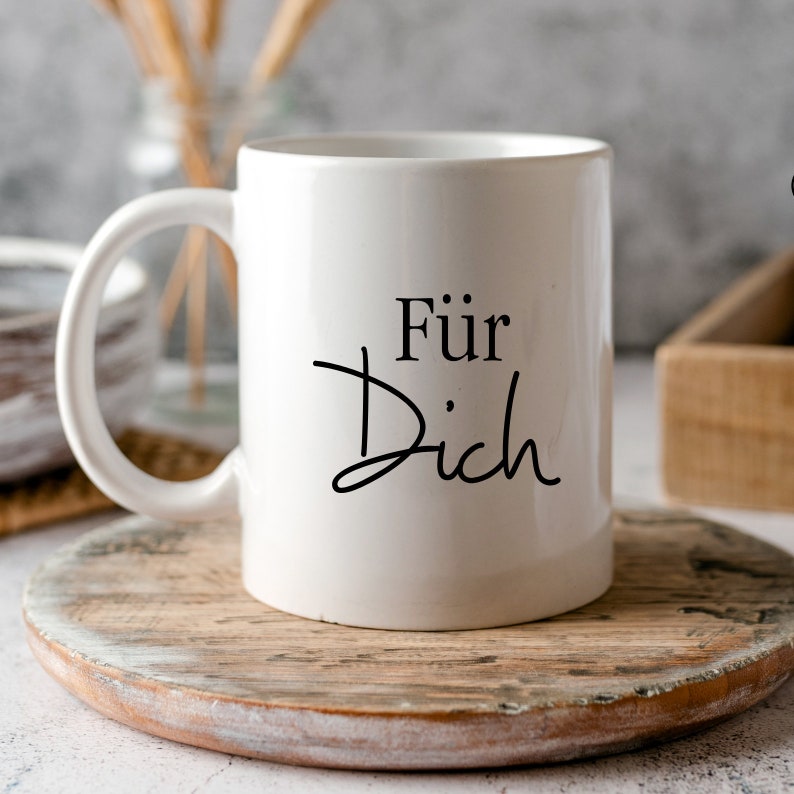 May include: White ceramic mug with a black inscription that reads "F&uuml;r Dich".