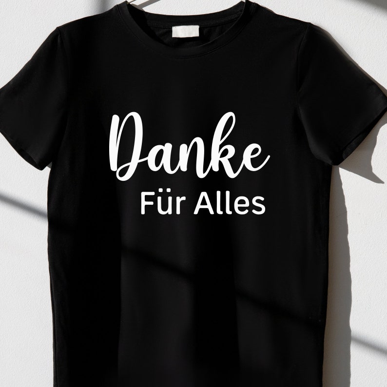 May include: Black t-shirt with white text that says "Danke f&uuml;r Alles".