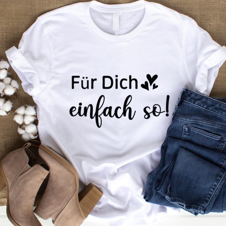 May include: White t-shirt with the German text "F&uuml;r Dich einfach so!" in black script. The shirt is paired with blue jeans and tan ankle boots. The text includes two small heart symbols.