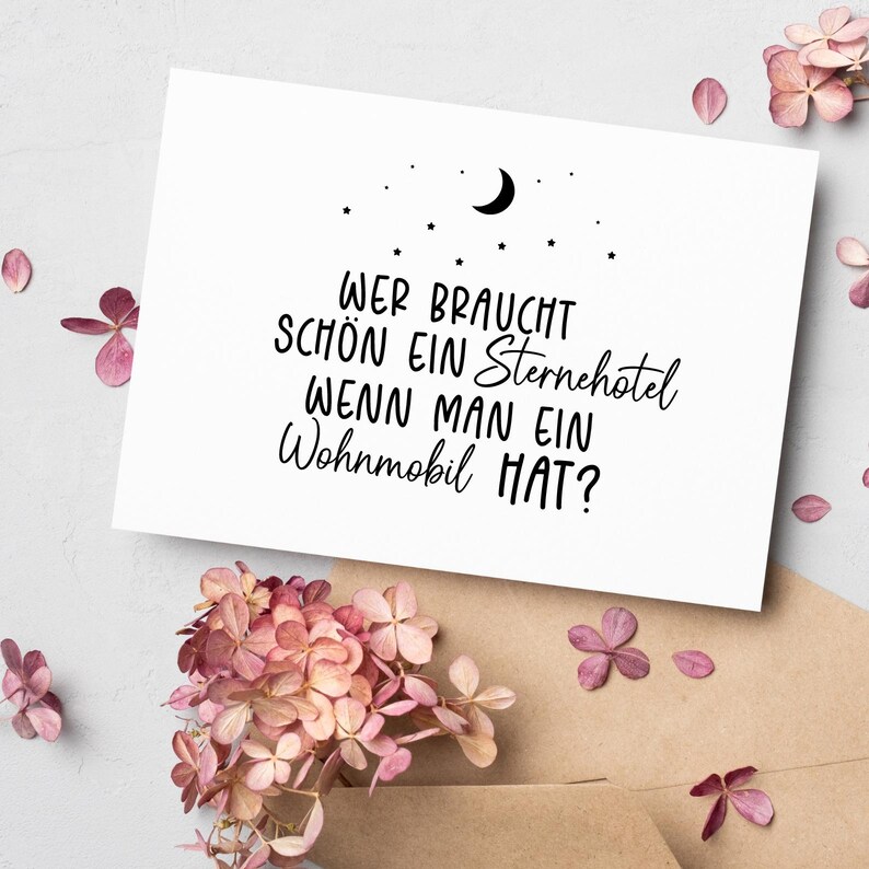 May include: A white card with black text that reads "Wer braucht schon ein Sternehotel wenn man ein Wohnmobil hat?"  The text is written in a handwritten style. There is a crescent moon and stars above the text.