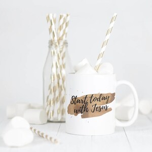 Könnte beinhalten: Eine weiße Keramiktasse mit einem braunen Aquarelldesign und dem Text "Start today with Jesus" in Schwarz. Die Tasse ist mit Marshmallows gefüllt und hat einen gold-weiß gestreiften Strohhalm.