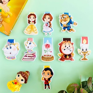 Puede incluir: Un conjunto de diez marcadores de libros coloridos con personajes de la película de Disney La Bella y la Bestia. Los marcadores están hechos de cartulina resistente y presentan una variedad de personajes, incluyendo Bella, Bestia, la señora Tetera, Lumière, Din Don y Chip.