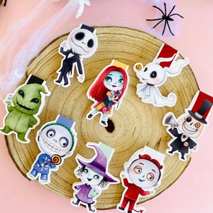 Puede incluir: Conjunto de ocho marcadores de libros coloridos con personajes de Pesadilla antes de Navidad. Los marcadores están impresos en cartulina blanca y presentan una variedad de personajes, incluyendo a Jack Skellington, Sally, Oogie Boogie y Zero.