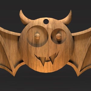 May include: Wooden bat-shaped decoration with a cartoonish face, horns, and large wings. The bat has a smiling mouth with fangs and large, round eyes. The wood grain is visible, and there is a hole at the top for hanging.